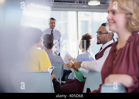 Business people talking in conference audience Stock Photo