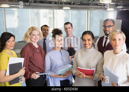 Portrait smiling business people with paperwork in conference room Stock Photo