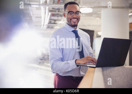 Portrait smiling businessman using laptop in office Stock Photo