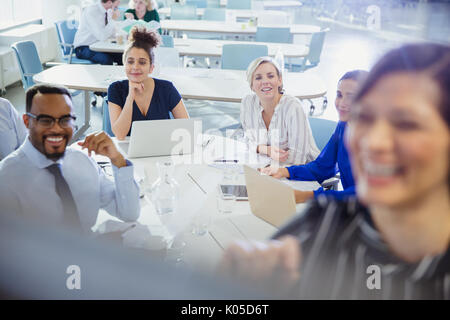 Business people with laptops listening in conference room meeting Stock Photo