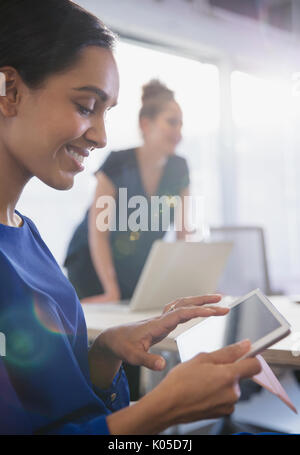 Smiling businesswoman using digital tablet in conference room meeting Stock Photo