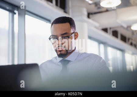 Serious, focused businessman working at laptop in office Stock Photo