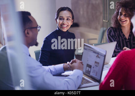Smiling business people with laptops talking in conference room meeting Stock Photo