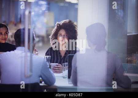 Businesswoman listening in dark conference room meeting Stock Photo