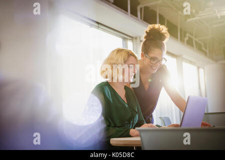Businesswomen using laptop in office Stock Photo