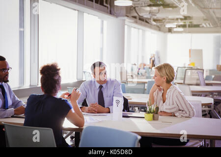 Business people talking at table in shared workspace Stock Photo