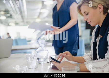 Businesswoman using digital tablet in office meeting Stock Photo