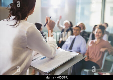 Businesswoman leading conference presentation, answering audience questions Stock Photo