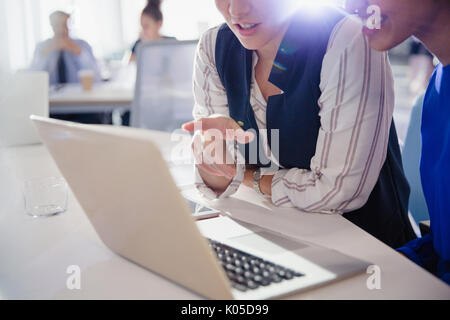 Businesswomen talking, working at laptop in office meeting Stock Photo