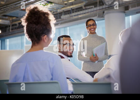 Smiling business people talking in conference audience Stock Photo