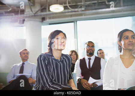 Attentive businesswoman listening in conference audience Stock Photo
