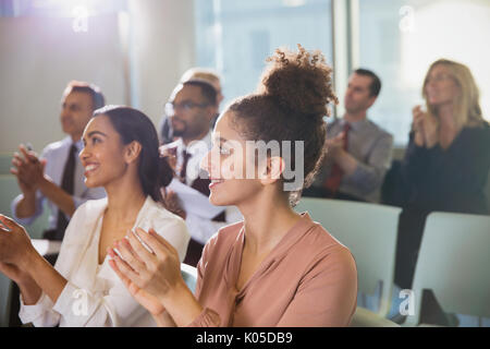 Businesswomen clapping in conference audience Stock Photo