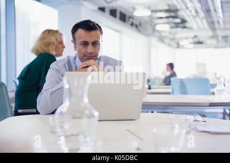 Focused, serious businessman working at laptop in office Stock Photo