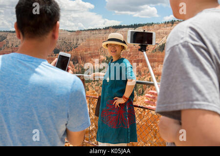 Tourists taking photos amongst the abstract rock formations in Bryce Canyon national Park in Utah, USA. Stock Photo