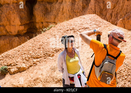 Tourists taking photos amongst the abstract rock formations in Bryce Canyon national Park in Utah, USA. Stock Photo