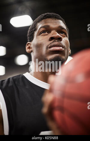 Close up portrait serious, focused young male basketball player shooting the ball Stock Photo