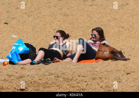 West Bay, Dorset, UK. 21st August 2017.   UK Weather.  Sunbathers enjoying the warm sunny weather on the beach at the seaside resort of West Bay in Dorset as summer makes an appearance after weeks of unsettled conditions.  Photo Credit: Graham Hunt/Alamy Live News Stock Photo