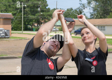 Vernon, Alabama, USA. 21st Aug, 2017. Andrea, right, and another employee of the local Pizza Hut in Vernon, Alabama try to photograph the solar eclipse on a phone. Monday, Aug. 21st brought a lot of people out to see the eclipse. Credit: Tim Thompson/Alamy Live News Stock Photo