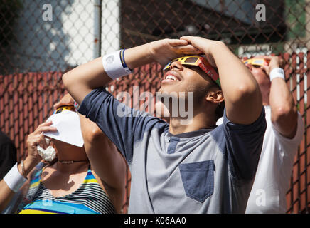 New York, USA. 21st Aug, 2017. Patrons at the West Farms Library in the Bronx watch the solar eclipse on 21 August 2017. The eclipse reached a maximum of 75% totality at approximately 2:45pm. Credit: Wanda Lotus/Alamy Live News Stock Photo