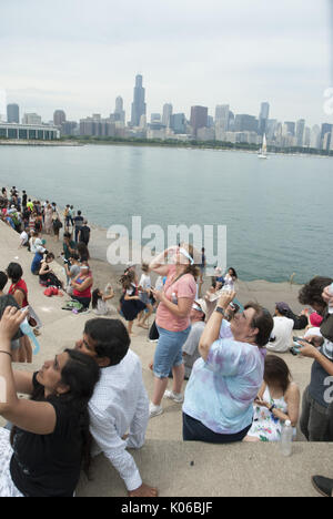 Chicago, Illinois, USA. 21st Aug, 2017. On August 21, 2017, the solar eclipse mesmerized people across the U.S. as the moon passed between the sun and earth. In Chicago, thousands headed toward the Adler Planetarium by car, by bus or by walking. The Museum handed out 35,000 pairs of special eclipse glasses so that individuals could safely experience this once in a lifetime phenomenon. The lakefront by the Planetarium also has one of the best views of the Chicago skyline. At 1:19 PM, the coverage reached its peak in Chicago- not quite reaching totality, but still quite impressive. (Cred Stock Photo