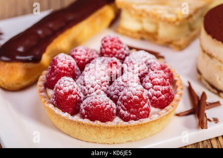 close up shot of Delicious raspberry mini tarts with fresh raspberries and icing sugar Stock Photo