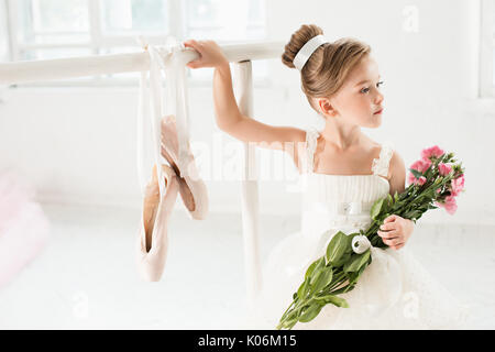 Little ballerina girl in a tutu. Adorable child dancing classical ballet in a white studio. Stock Photo