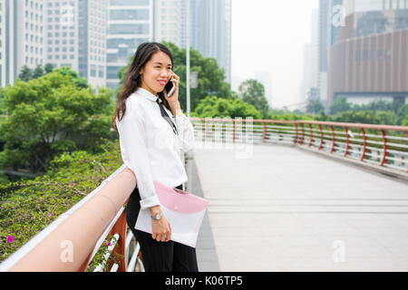 Business woman having a phone call outside Stock Photo