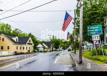 Blue Hill, USA - June 9, 2017: American flag on city main street in Maine during rainy cloudy weather with directions Stock Photo
