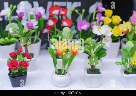 Small clay flower pots with many colors displayed on the shelf. This is a handmade artwork that creates works close to nature Stock Photo