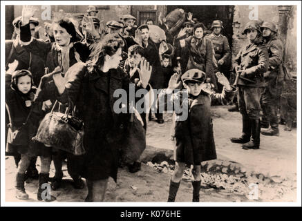 WARSAW GHETTO BOY SURRENDER JEWISH WOMEN & CHILDREN This poignant WW2 image shows Jewish men women and children from the Warsaw ghetto surrendering to German soldiers after the brave valiant uprising. Evacuation of the Warsaw Ghetto, used as evidence ( Stroop Report) during the Nuremberg Trials, 1945/6  Note the small Polish infant boy in centre background with admirable defiance to the Nazi German photographer putting his tongue out to the camera Stock Photo