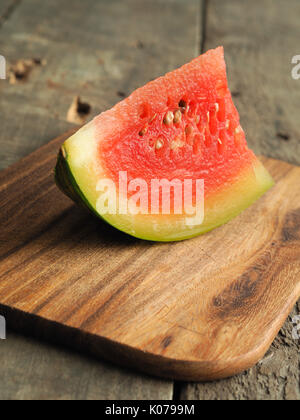Piece of a water melon on a wooden cutting board Stock Photo