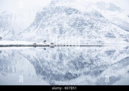 Perfect reflection of mountains and red house, Lofoten Islands, Norway Stock Photo