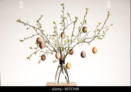 Vase with tree branches and multicolored hand painted easter eggs Stock Photo