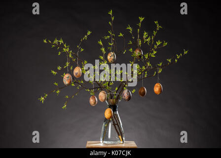 Vase with tree branches and multicolored hand painted easter eggs Stock Photo