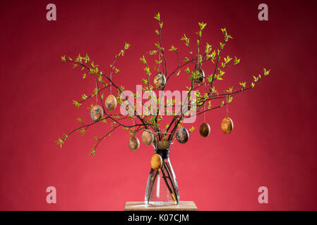 Vase with tree branches and multicolored hand painted easter eggs Stock Photo