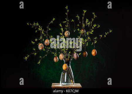 Vase with tree branches and multicolored hand painted easter eggs Stock Photo