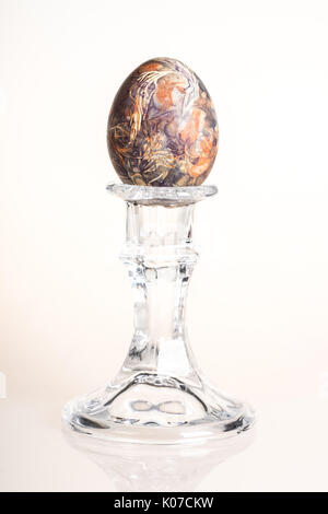 Multicolored hand painted easter egg on candlestick Stock Photo