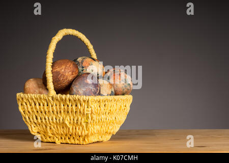Multicolored hand painted easter eggs in the yellow basket Stock Photo