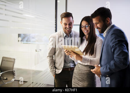Team of colleagues working together on tablet Stock Photo