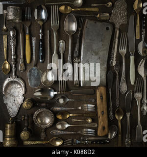 Cutlery, forks, spoons, and knives on dark wooden background Stock Photo