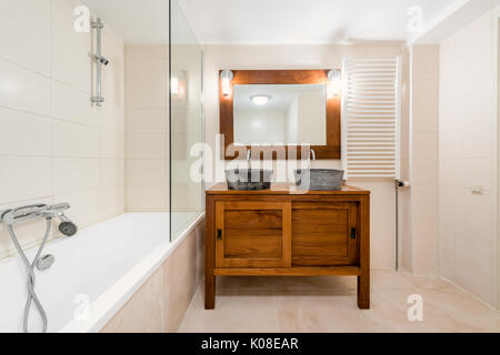 Modern Bathroom with Double Sink, Mirror, Bathtub and Design Radiator Stock Photo