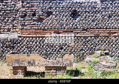 Archaeological site of Ostia Antica: Wall with chromatic decorations and sarcophagus Stock Photo