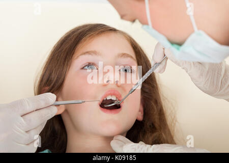 Close-up portrait of girl with mouth open going through dental examination in clinic Stock Photo
