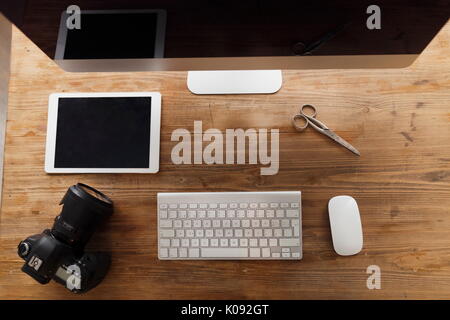Picture of computer, scissors and camera on working desk Stock Photo