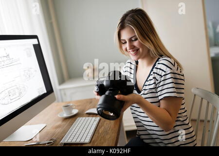 Picture of young female designer holding camera Stock Photo