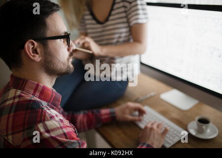 Beautiful woman and attractive man doing design work Stock Photo