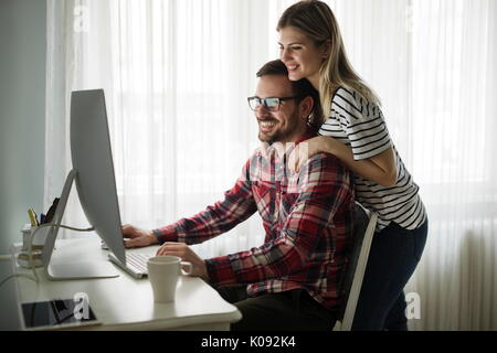 Beautiful woman and attractive man doing design work Stock Photo