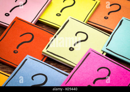 question mark concept  - handwriting in black ink on colorful sticky notes against rustic wood Stock Photo