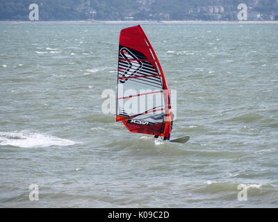 A windsurfer sails on the Solent with the Isle of Wight in the background Stock Photo