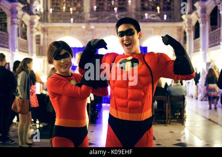 Two college students, male on the right, female on the left, dressed as Mr and Mrs Incredible, with partygoers and the stage in the background, Halloween at Peabody, October 31, 2015. Courtesy Eric Chen. Stock Photo